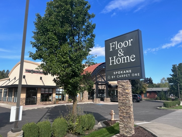 Living room with soft grey and cream furniture and carpet.