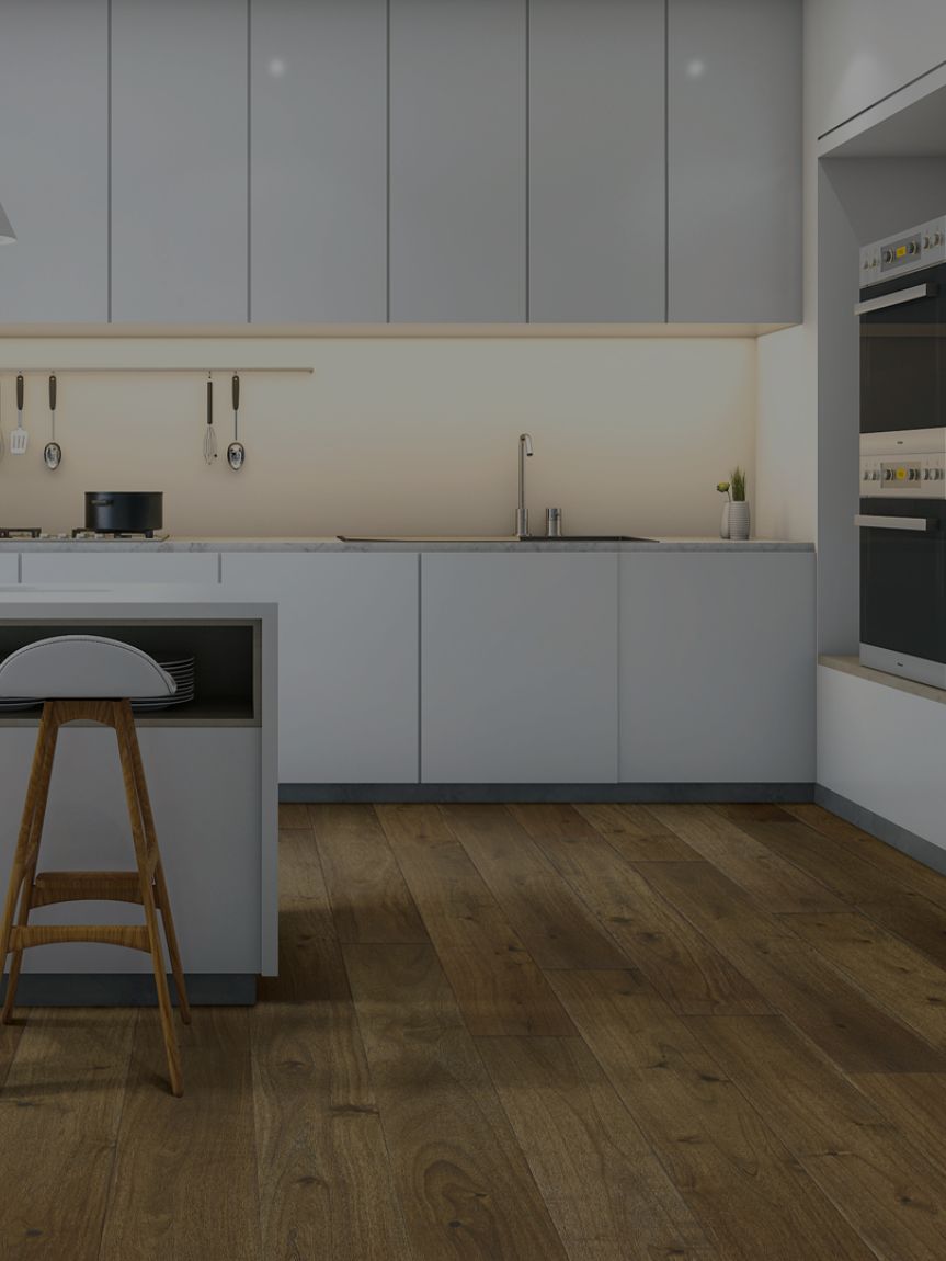 A kitchen with white cabinets and countertops and wood floors.